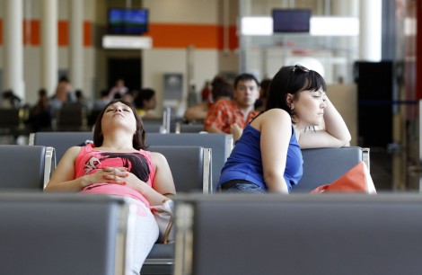 People sit in a waiting room at Moscow's Sheremetyevo airport June 26, 2013. Ecuador said on Wednesday the United States must "submit its position" regarding Edward Snowden to the Ecuadorean government in writing as it considers the former U.S. spy agency contractor's request for asylum. Snowden, 30, a former employee of the U.S. contractor Booz Allen Hamilton, appears to be still in hiding at a Moscow airport awaiting a ruling on his asylum request from the tiny South American nation's leftist government.  REUTERS/Sergei Karpukhin (RUSSIA - Tags: POLITICS SOCIETY TRANSPORT)